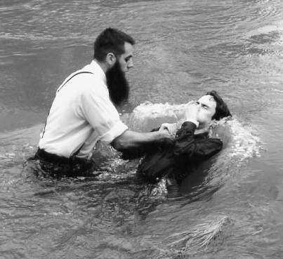 A man baptizing another man in water