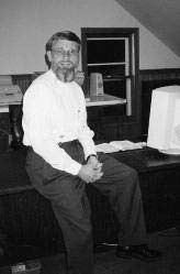 Denny Kenaston seated indoors
