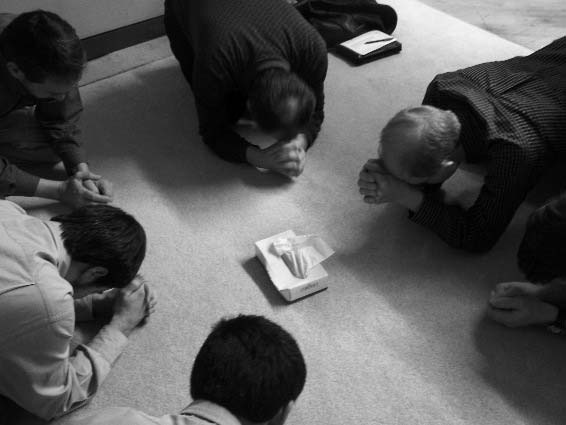 Men kneeling together in prayer at the seminar