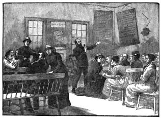 People gathered inside a room as a man addresses them.