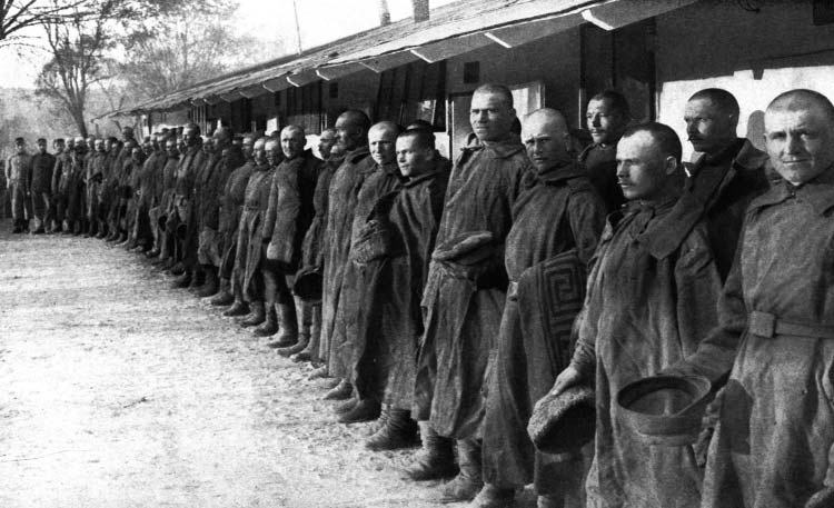 A long line of prisoners standing outside a building