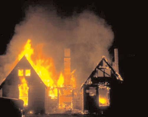Flames and smoke rising from a burning house.