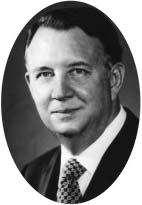 A portrait of a man wearing a suit and patterned tie.