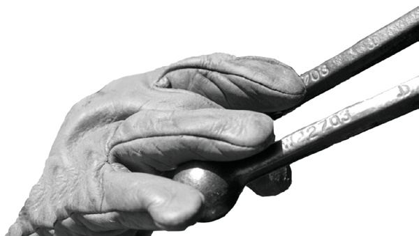 A hand holding two forklift control levers
