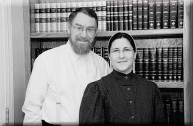 Michael and Kayra McDaniel standing together in front of bookshelves