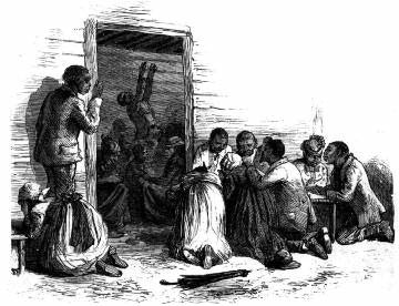 A man addresses a kneeling group gathered outside a building