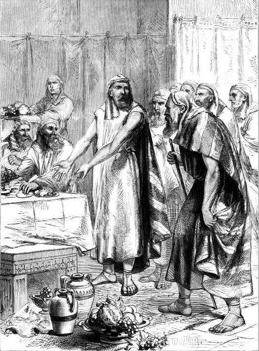 Robed men standing beside a table