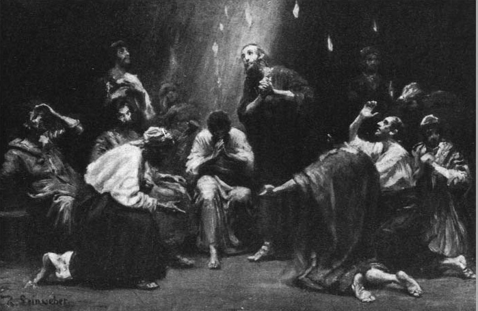 A gathering in a dark room with a man standing at the center