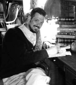 A man seated at a desk beside a window