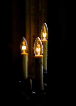 Three candle-shaped lights glowing in darkness