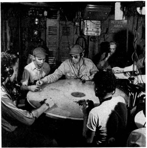 Military personnel gathered around a circular plotting table