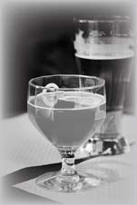 A beverage glass with another vessel behind it