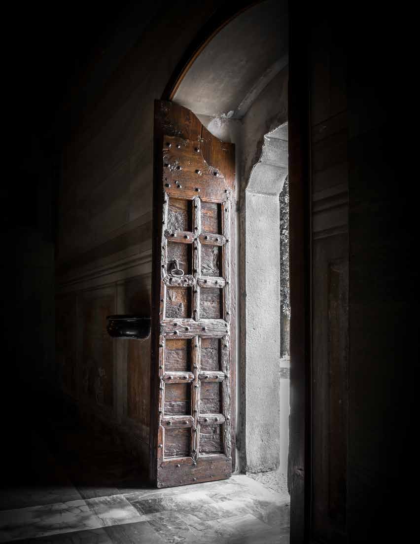 An old wooden door opening into bright light