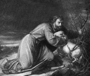 Jesus kneeling in prayer beside a rock.