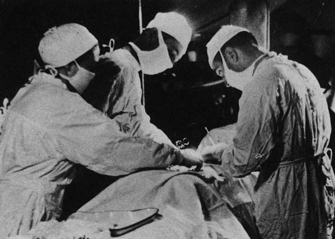 Masked medical staff performing surgery