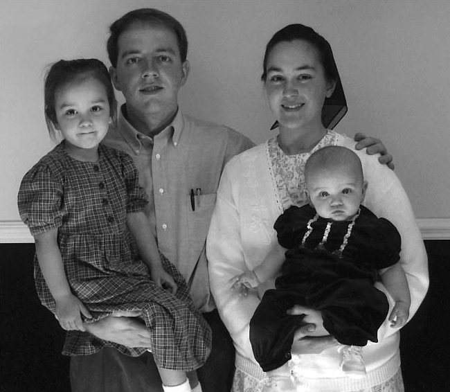 A man and woman holding two young children