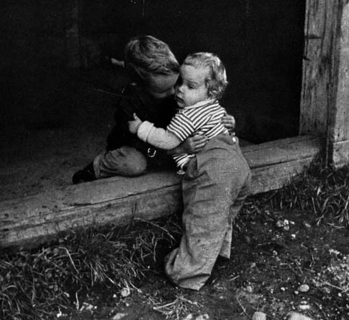 Two young children beside a doorway