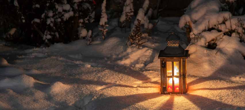 A glowing lantern on a snowy path at night