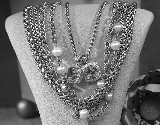 Necklaces and pearl-like beads displayed on a jewelry bust