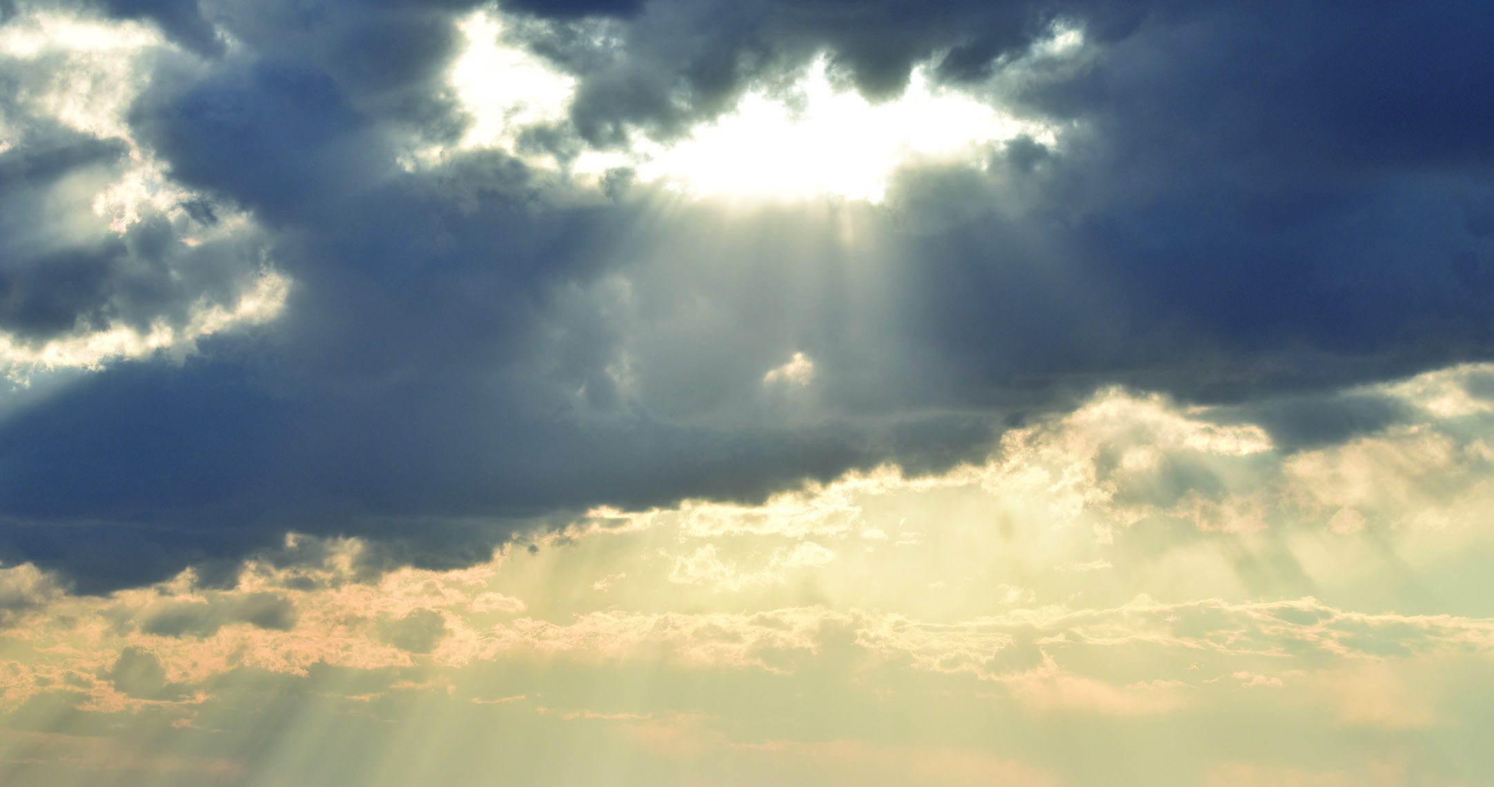 Sunbeams shining through dark clouds