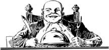 A smiling man seated at a dining table with a knife and fork.