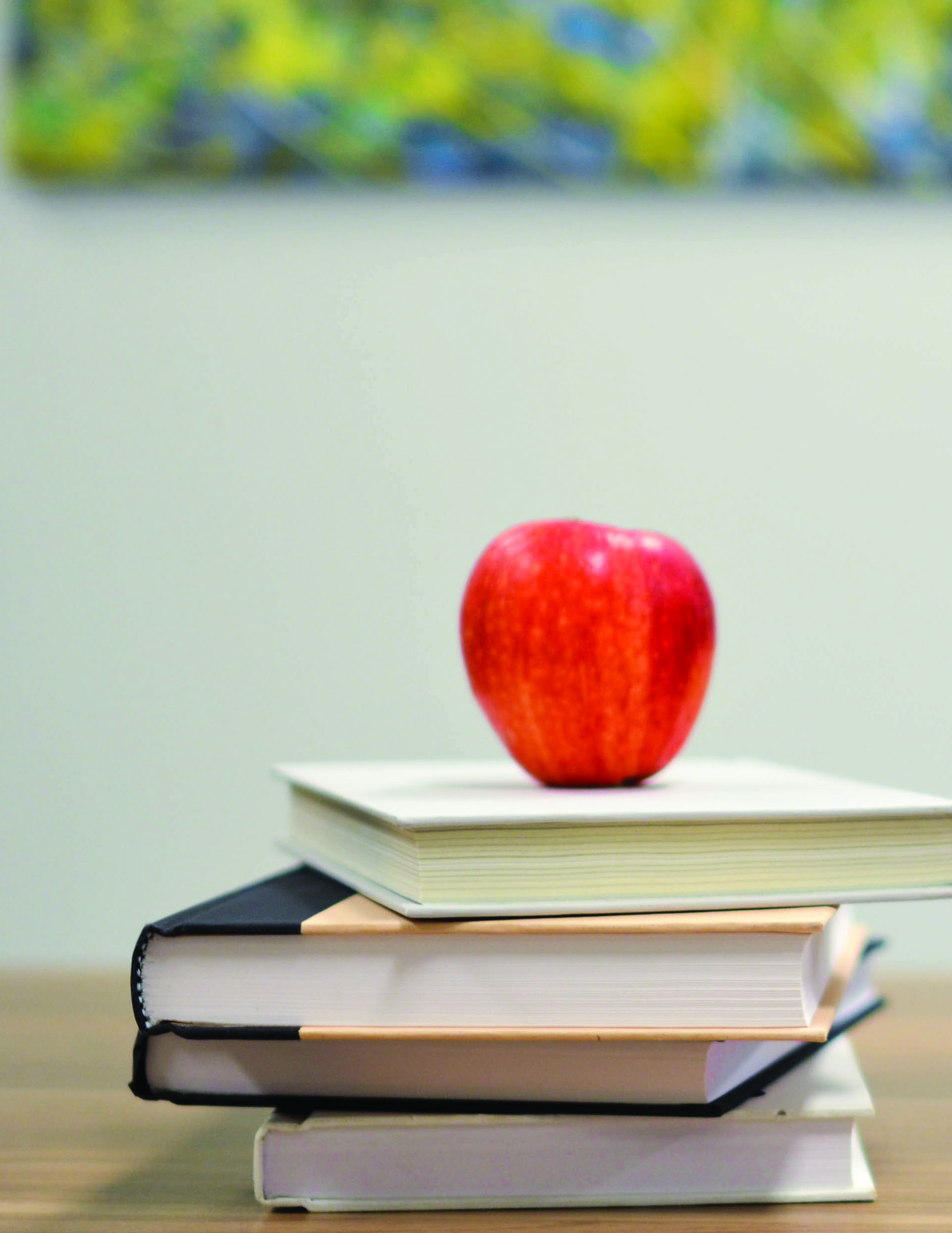 A red apple resting on a stack of books