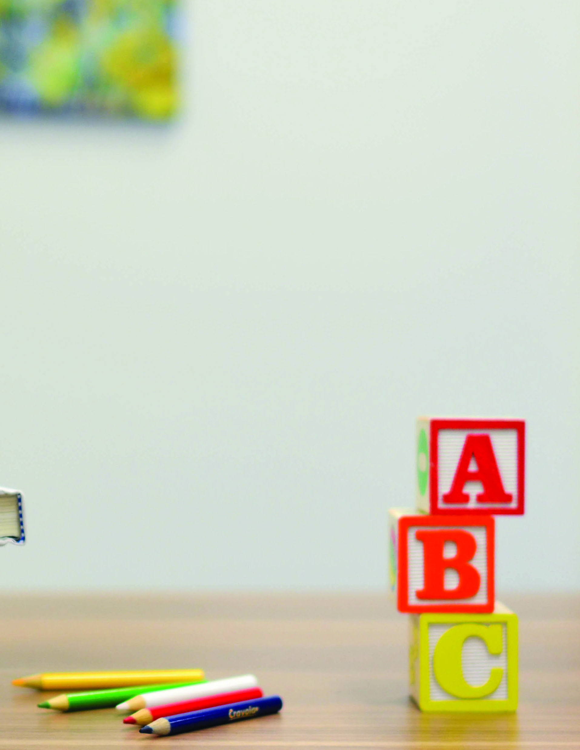 Colored pencils and alphabet blocks on a desk