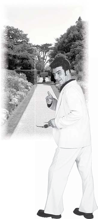 A man in a light suit stands by a garden walkway
