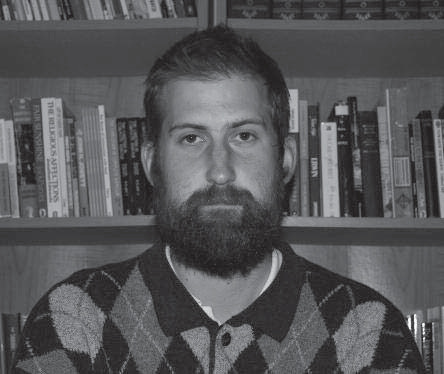Portrait of Greg Gordon in front of bookshelves