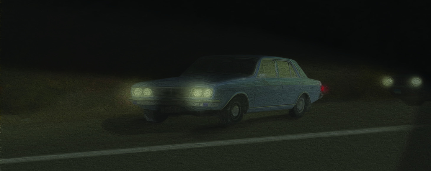 An old car stopped on a dark road with another vehicle's headlights behind it