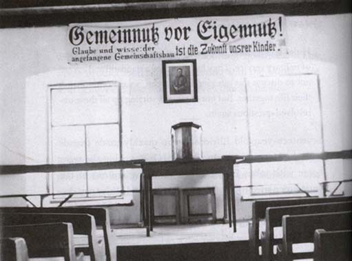 The interior of the Fernheim Colony meeting hall with a portrait of Adolf Hitler above the front table