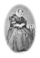 Susanna Murray seated beside a table.