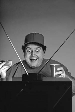 A smiling performer standing behind a stage apparatus