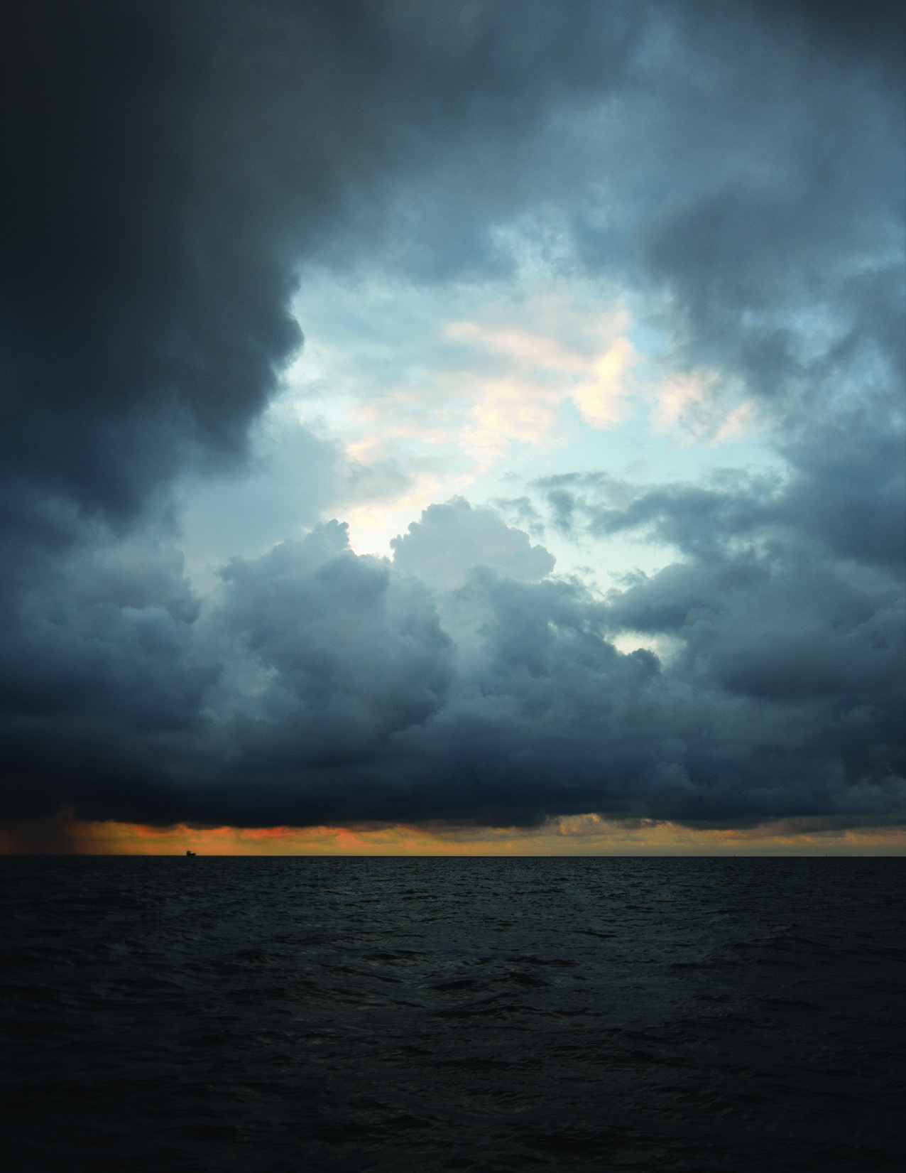 Dark storm clouds over calm water