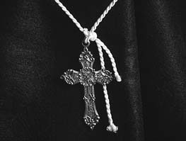 A cross pendant hanging from a cord
