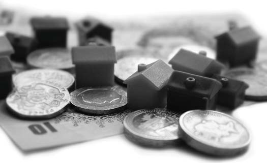 Board-game houses and coins scattered on paper money