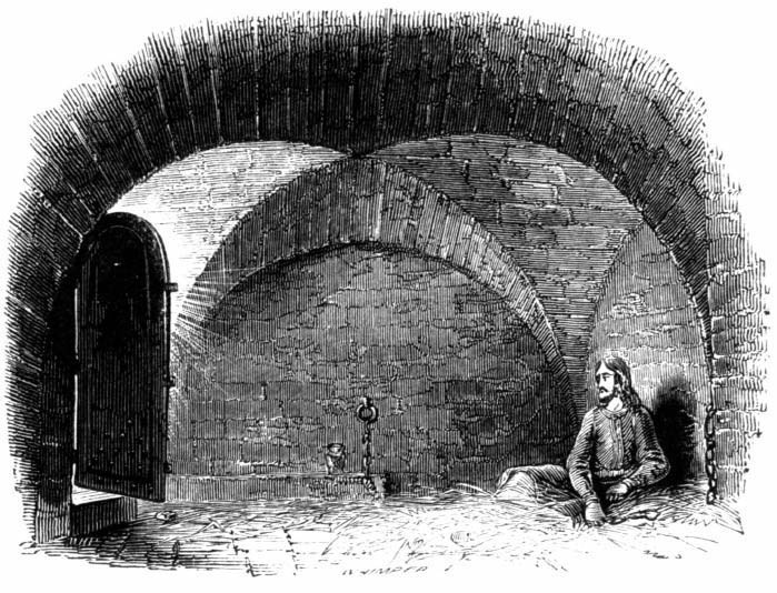 A man sitting in a stone prison cell beneath vaulted arches
