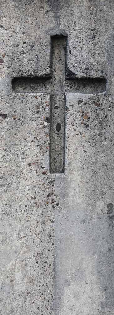 A cross recessed into a weathered stone wall