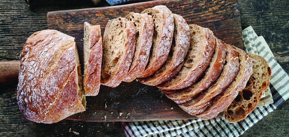 A sliced loaf of bread on a wooden board