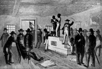 An auctioneer and two people on a platform before a gathered crowd