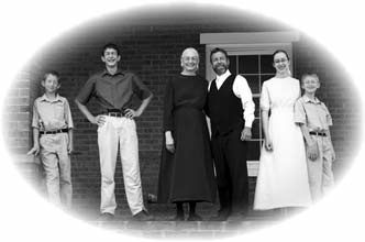 Ken Miller standing with his family outside a building