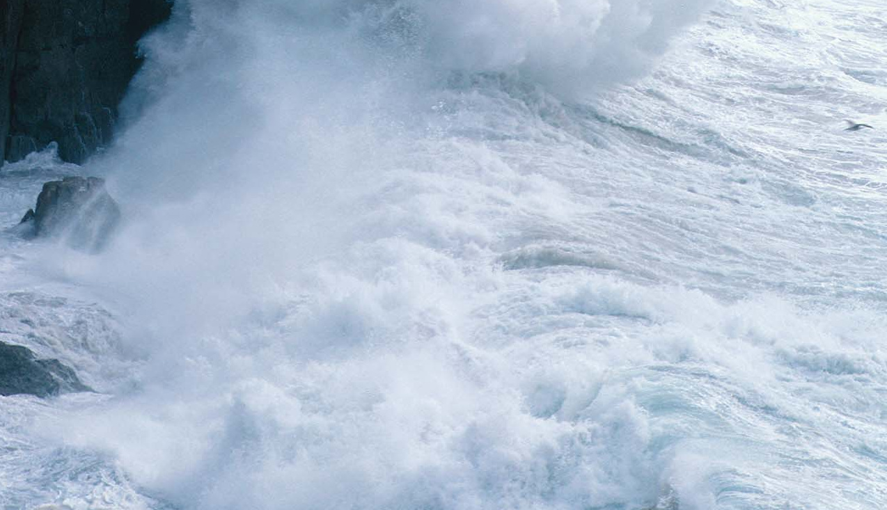 Ocean waves breaking against a rocky cliff