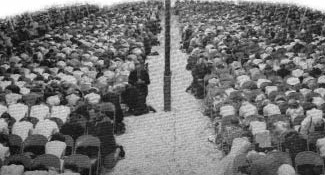Congregation kneeling inside a revival tent