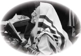 A seated Jewish man wearing a prayer shawl