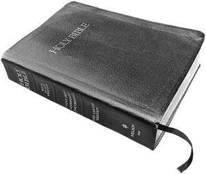 A closed black Holy Bible with a ribbon bookmark
