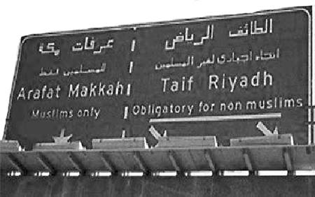 Road sign with Arabic and English place names.