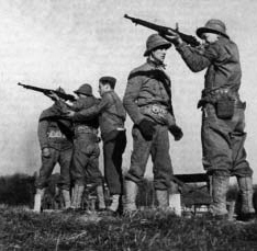 Soldiers holding rifles outdoors.