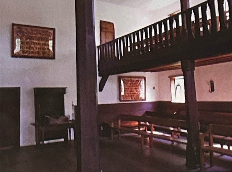 Wooden benches and a balcony inside the Saal meeting house.