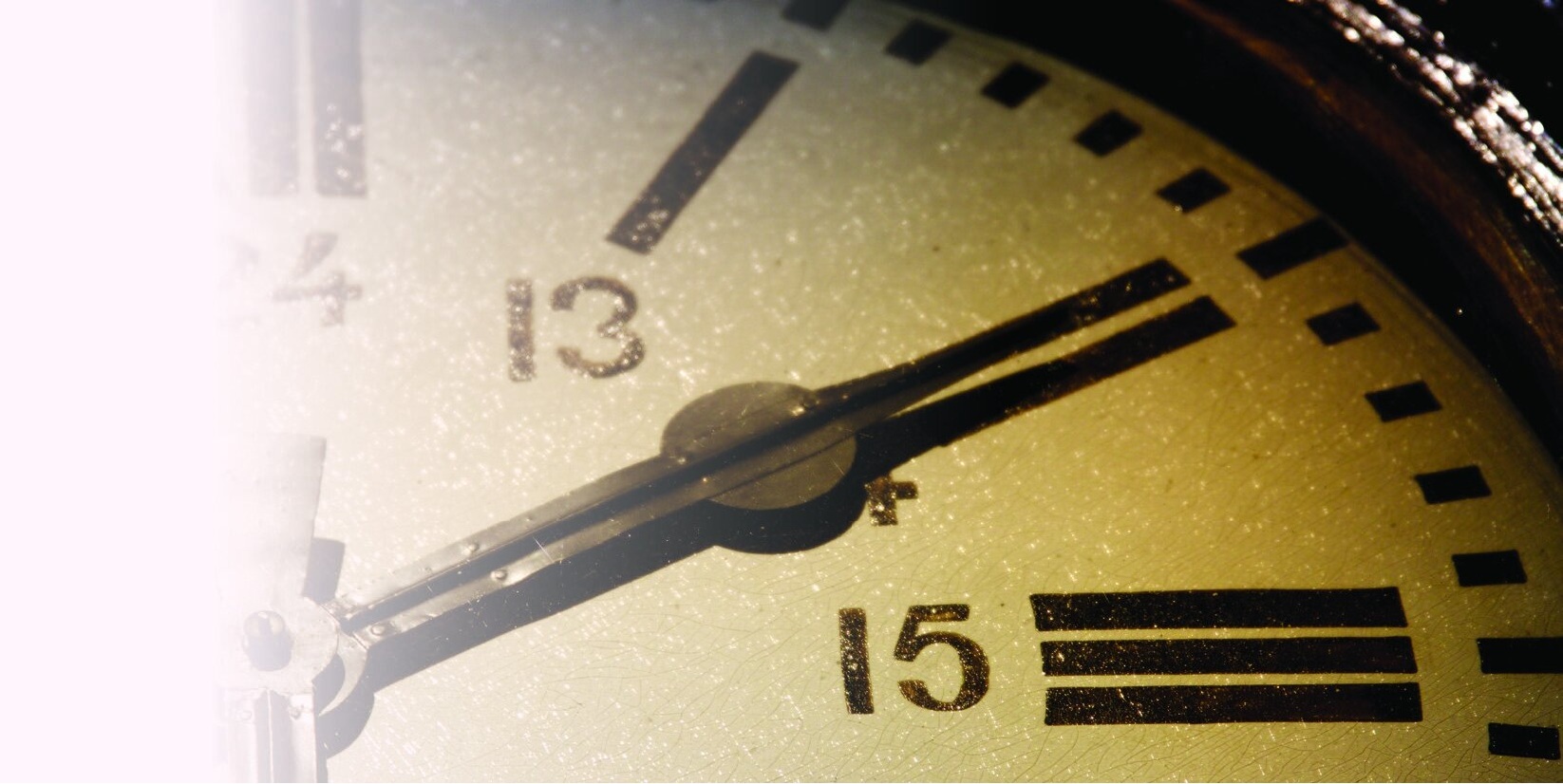 Close-up of an analog clock face behind a white fade