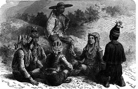 A man wearing a hat speaks to a seated group outdoors